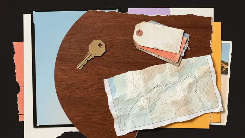 Top-down view of a wooden table with a brass room key, blank luggage tags, and a folded paper map.