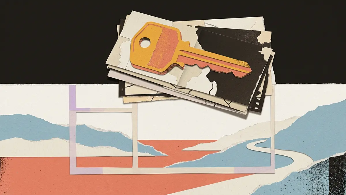 A brass room key sits on folded blank maps behind a paper-cut window frame.