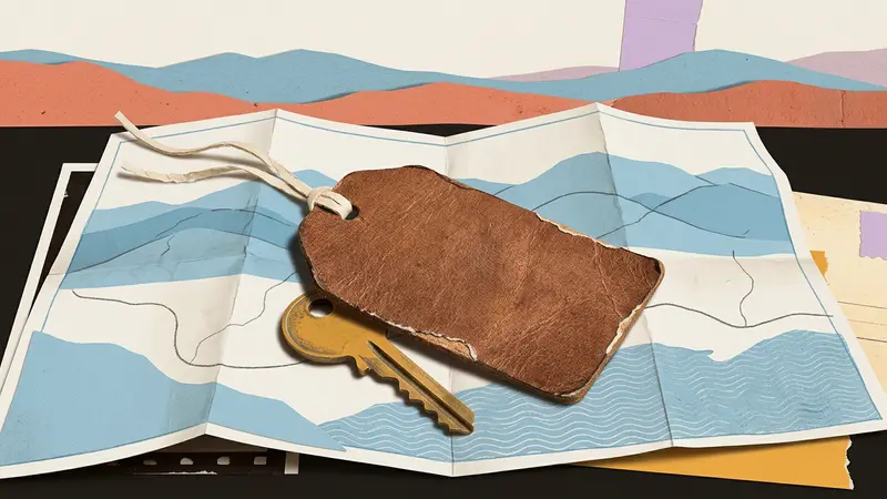 Close-up of a luggage tag and brass room key resting on top of a folded, unlabeled paper map.