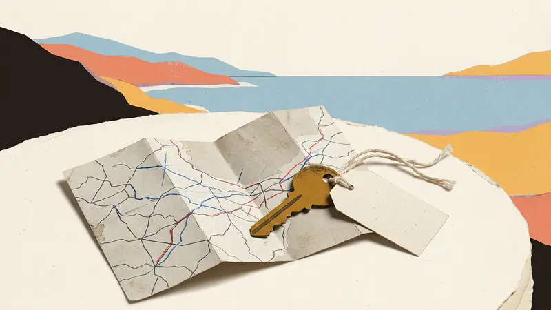 A brass room key and a blank luggage tag sit on top of a folded map on a sunny café table.
