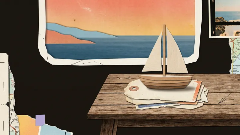 Wooden boat on luggage tags on a café table in front of a window overlooking the ocean.