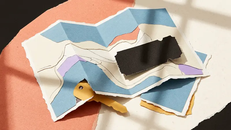 A layered papercraft scene of a folded map, a brass key, and a ticket stub on a café table.
